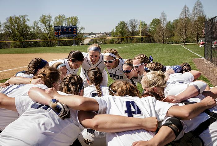 The softball team huddles together before a game